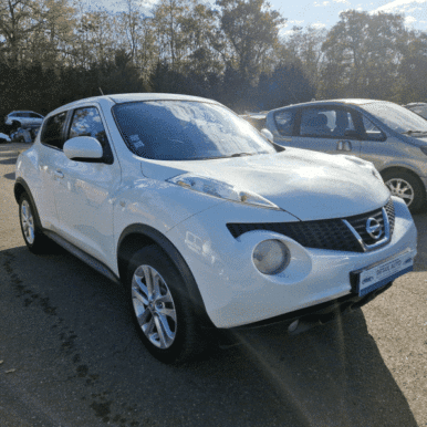SUV Nissan Juke blanc d'occasion garé sur un parking chez Detail Auto, design compact et moderne sous le soleil.