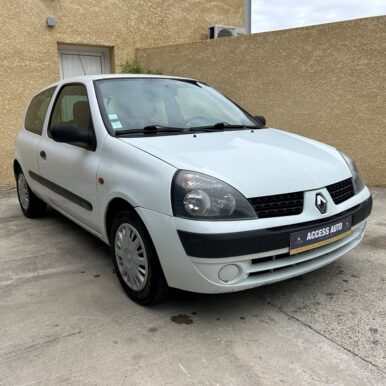 Renault Clio 2 blanche 3 portes avec plaque Access Auto et badge 1.4 16V, stationnée devant un mur beige.